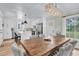 Open dining area with a large wooden table, tufted chairs, and a modern light fixture at 905 Tyler Ct, Garner, NC 27529