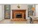 Brick fireplace with wooden mantle adds warmth and character to the room at 918 Albany Ct, Raleigh, NC 27615