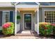 Charming home entrance with black door, featuring a covered porch, colorful landscaping, and inviting curb appeal at 918 Albany Ct, Raleigh, NC 27615