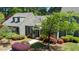 Inviting gray home featuring a picturesque front yard with a manicured lawn, colorful bushes, and mature trees at 918 Albany Ct, Raleigh, NC 27615
