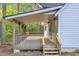 Covered back porch with wood railing and stairs leading to the yard at 924 Lynn Rd, Durham, NC 27703
