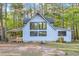 Charming light blue home with a covered porch, offering a glimpse into the tranquil wooded surroundings at 924 Lynn Rd, Durham, NC 27703