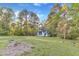 Scenic shot of a light blue home nestled within a large, tree-lined lot and sunny blue skies at 924 Lynn Rd, Durham, NC 27703