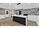 Modern kitchen features an island, stainless steel appliances, and marble-patterned accent wall at 924 Lynn Rd, Durham, NC 27703