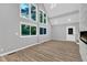 Bright living area with modern floors, tall windows, fireplace, and a view to the lush backyard scenery at 924 Lynn Rd, Durham, NC 27703