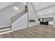 Open-concept living area featuring a modern fireplace, staircase, and a glimpse of the kitchen with a countertop bar at 924 Lynn Rd, Durham, NC 27703