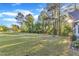 Spacious, lush green yard with mature trees and a glimpse of the home's exterior and neighborhood street at 924 Lynn Rd, Durham, NC 27703