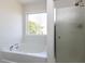 Bright bathroom featuring a shower and a separate bathtub with large picture window at 929 Mailwood Dr, Knightdale, NC 27545