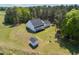 Aerial view of a beautiful white home, shed and lush green yard with a backdrop of mature trees at 9947 Nc Hwy 96 N, Selma, NC 27576