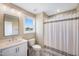 Bathroom with a white vanity and shower with gray and white striped shower curtain at 9947 Nc Hwy 96 N, Selma, NC 27576
