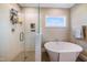 Bright bathroom features a soaking tub, glass-enclosed shower, and a large window at 9947 Nc Hwy 96 N, Selma, NC 27576