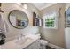 Powder room featuring a round mirror, modern vanity, and decorative shelves at 9947 Nc Hwy 96 N, Selma, NC 27576