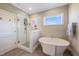Bathroom features a soaking tub, glass-enclosed shower, and a large window at 9947 Nc Hwy 96 N, Selma, NC 27576