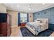 Bright bedroom features tray ceilings, blue accent wall, a ceiling fan, and wooden floors at 9947 Nc Hwy 96 N, Selma, NC 27576
