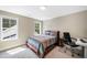 Bright bedroom with a bed, desk, and chair near the window overlooking the trees at 9947 Nc Hwy 96 N, Selma, NC 27576