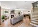 Open-concept living room featuring light wood floors, a fireplace, a ceiling fan, and seamless access to the kitchen at 9947 Nc Hwy 96 N, Selma, NC 27576
