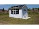 Outdoor storage shed with windows and doors in a lush green yard at 9947 Nc Hwy 96 N, Selma, NC 27576