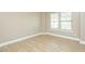Neutral bedroom featuring hardwood floors and natural light from the double windows at 1004 Longleaf Pine Pl, Mebane, NC 27302
