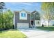 Charming two-story brick home with attached garage, and manicured lawn on a sunny day at 1004 Longleaf Pine Pl, Mebane, NC 27302