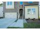 Stylish two-story home featuring a brick and stone facade, attached garage and landscaped walkway at 1004 Longleaf Pine Pl, Mebane, NC 27302