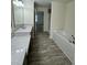 Bathroom featuring double vanity sinks, ample counter space, and a soaking tub, ideal for modern living at 1010 Pool Rock Rd, Henderson, NC 27537