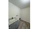 Laundry room features a utility sink with gray cabinets and wood-look flooring at 1010 Pool Rock Rd, Henderson, NC 27537