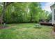 Spacious backyard featuring a picnic table, wooded area, and deck at 1027 Upchurch Farm Ln, Cary, NC 27519