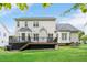 Spacious backyard with lush green lawn, deck and view of the house at 1027 Upchurch Farm Ln, Cary, NC 27519