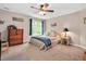 Cozy bedroom features a ceiling fan, plush carpet, and bright window at 1027 Upchurch Farm Ln, Cary, NC 27519