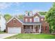 Charming two-story brick home with red shutters, landscaped lawn and a two-car garage at 1027 Upchurch Farm Ln, Cary, NC 27519