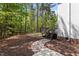 Sideyard backyard features brick pathway, wooded area, and deck with stairs at 103 Ticonderoga Rd, Cary, NC 27519