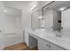 Well-lit bathroom featuring double sinks with wood-style flooring and a large mirror at 103 Ticonderoga Rd, Cary, NC 27519