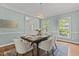 Well-lit dining room featuring neutral walls, a modern chandelier, hardwood floors, and a table set with elegant place settings at 103 Ticonderoga Rd, Cary, NC 27519