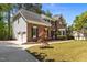 Exterior view showcasing a brick home with attached garage, manicured lawn, and mature landscaping at 103 Ticonderoga Rd, Cary, NC 27519