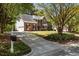 An expansive brick home with a long drive, lush landscaping, and an attached three-car garage at 103 Ticonderoga Rd, Cary, NC 27519