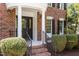 Elegant brick home featuring a covered entrance with classic columns and decorative glass front door with manicured landscaping at 103 Ticonderoga Rd, Cary, NC 27519