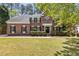 Beautiful brick home featuring manicured lawn, mature trees, classic shutters, and charming entry balcony at 103 Ticonderoga Rd, Cary, NC 27519