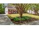 Stunning front yard with flowerbed, mature trees, and brick home with black shutters at 103 Ticonderoga Rd, Cary, NC 27519