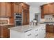 Open kitchen with a large island, custom wood cabinets, and modern stainless appliances at 103 Ticonderoga Rd, Cary, NC 27519