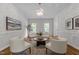 Serene living room with a neutral palette, modern chandelier, large windows, and hardwood floors creating a welcoming atmosphere at 103 Ticonderoga Rd, Cary, NC 27519