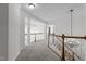 Upstairs landing with carpet, white pillars, and natural light from large windows in the home at 103 Ticonderoga Rd, Cary, NC 27519
