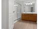 Bathroom featuring double sink vanity, framed mirror, and glass-enclosed shower stall at 107 Kinship Ln, Apex, NC 27502