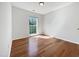 Empty bedroom features hardwood flooring and large window providing natural light at 107 Kinship Ln, Apex, NC 27502