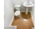 Cozy bathroom featuring wood-look flooring, white toilet, and pedestal sink at 108 Warm Wood Ln, Apex, NC 27539