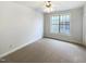 Neutral bedroom featuring plush carpeting, a ceiling fan, and a large window at 108 Warm Wood Ln, Apex, NC 27539