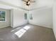 Sunny bedroom with ceiling fan features carpet, neutral walls, and a view to the trees at 108 Warm Wood Ln, Apex, NC 27539