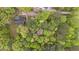 Stunning aerial view of a wooded property with a home nestled among lush, mature trees and green surroundings at 1106 Lake Ridge Dr, Creedmoor, NC 27522