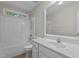 Well-lit bathroom featuring a shower-tub combination and a white vanity with a framed mirror at 1106 Lake Ridge Dr, Creedmoor, NC 27522