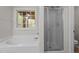 Bathroom with bathtub, window, and shower with glass doors at 1106 Lake Ridge Dr, Creedmoor, NC 27522