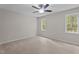 Bright bedroom featuring two windows, ceiling fan, neutral carpeting and light colored paint at 1106 Lake Ridge Dr, Creedmoor, NC 27522